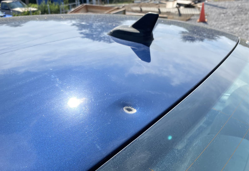 Before repair. Dent hole repaired on blue car