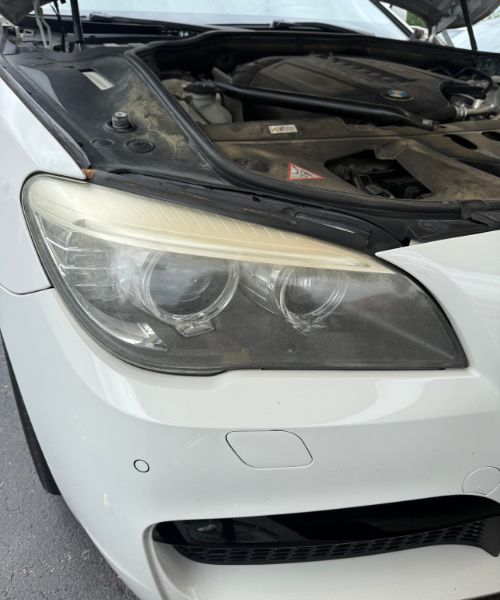 Cloudy BMW headlight with yellowed lens before restoration