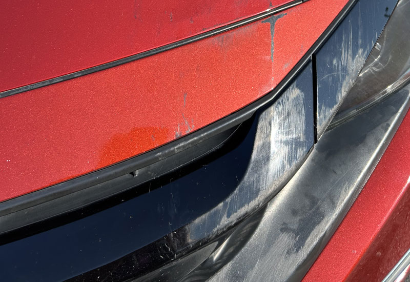 Before: White vehicle with visible scratches and dent on rear passenger-side panel above wheel.